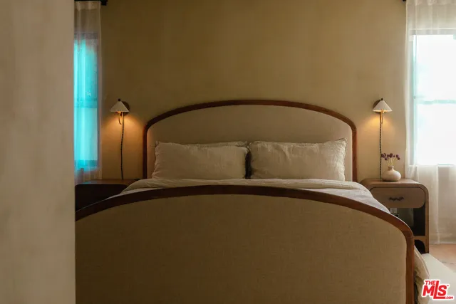 a bed sitting in a bedroom next to a window