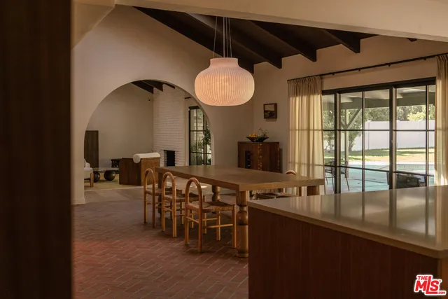 a dining room with furniture and a floor to ceiling window