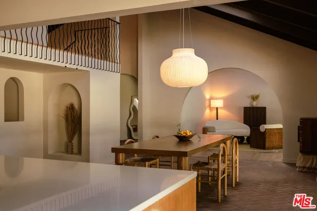 a living room with furniture a flat screen tv and kitchen area