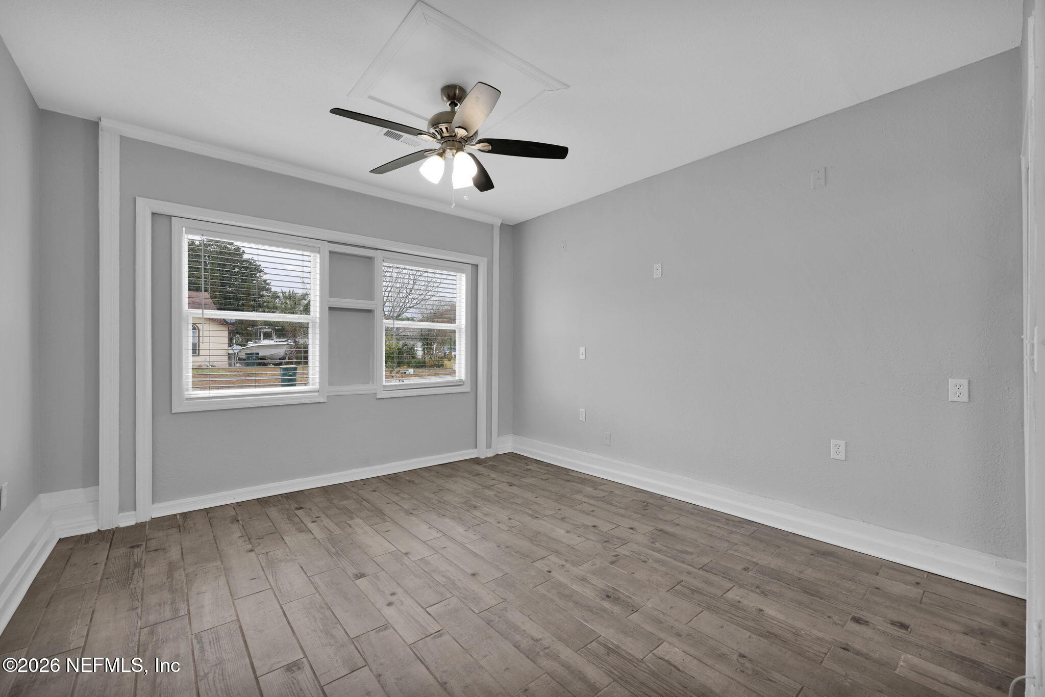 2494 Spring Vale Road Jacksonville, FL 32246 - Photo 27 of 36 a view of an empty room with wooden floor and a window