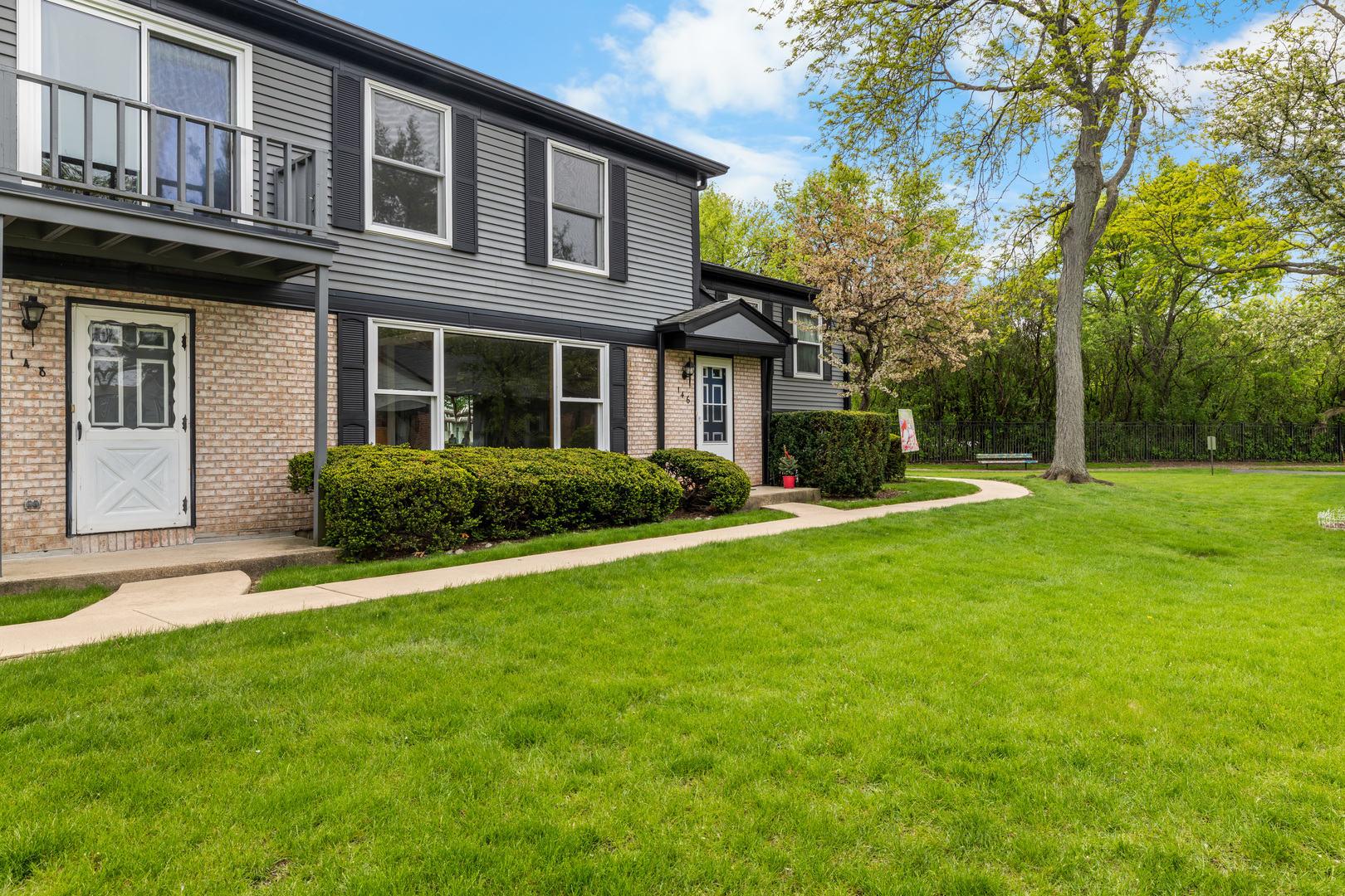 a front view of a house with a yard and trees