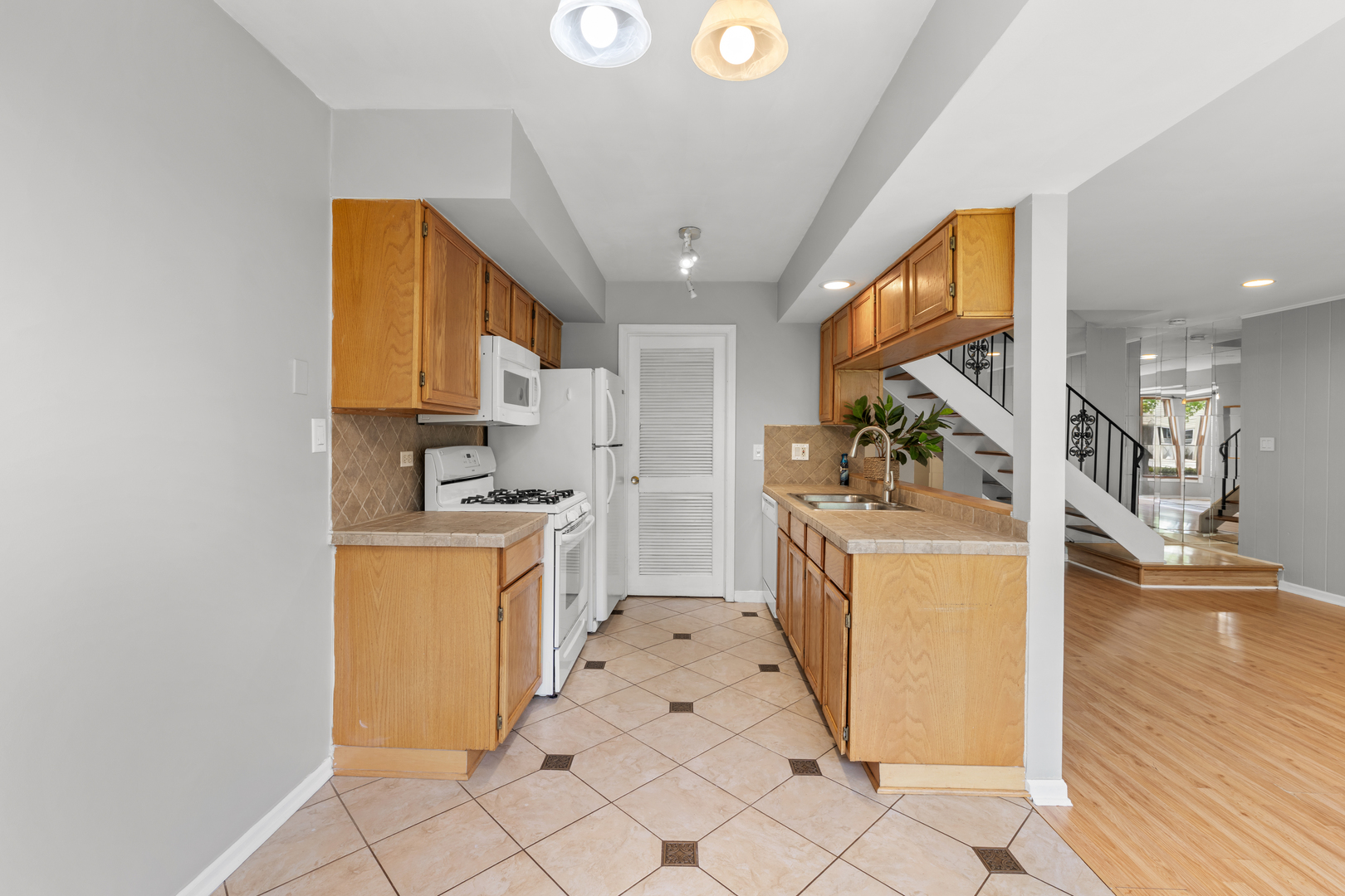 146 Inverrary Lane, Unit 146 Deerfield, IL 60015 - Photo 7 of 19 a kitchen with white cabinets and wooden floor