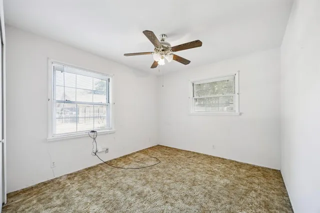 a view of a big room with wooden floor and a ceiling fan