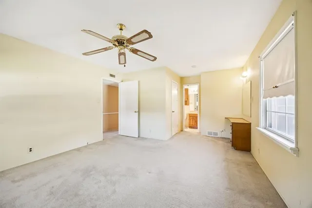 a view of a livingroom with a ceiling fan and window