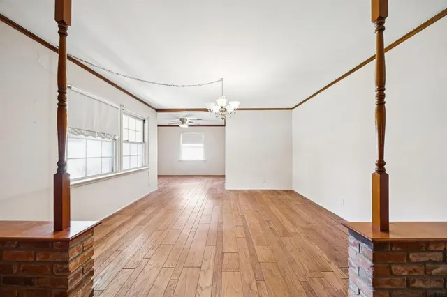 a view of a big room with wooden floor and windows