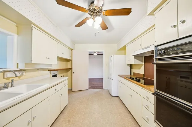 a kitchen with a sink stainless steel appliances and cabinets