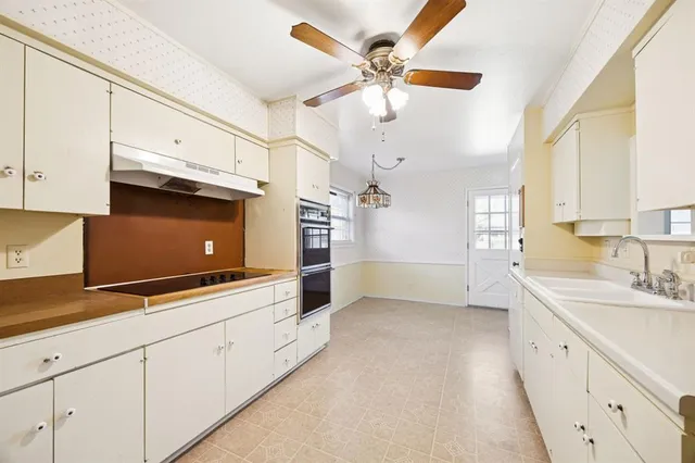a kitchen with granite countertop a sink appliances cabinets and a window