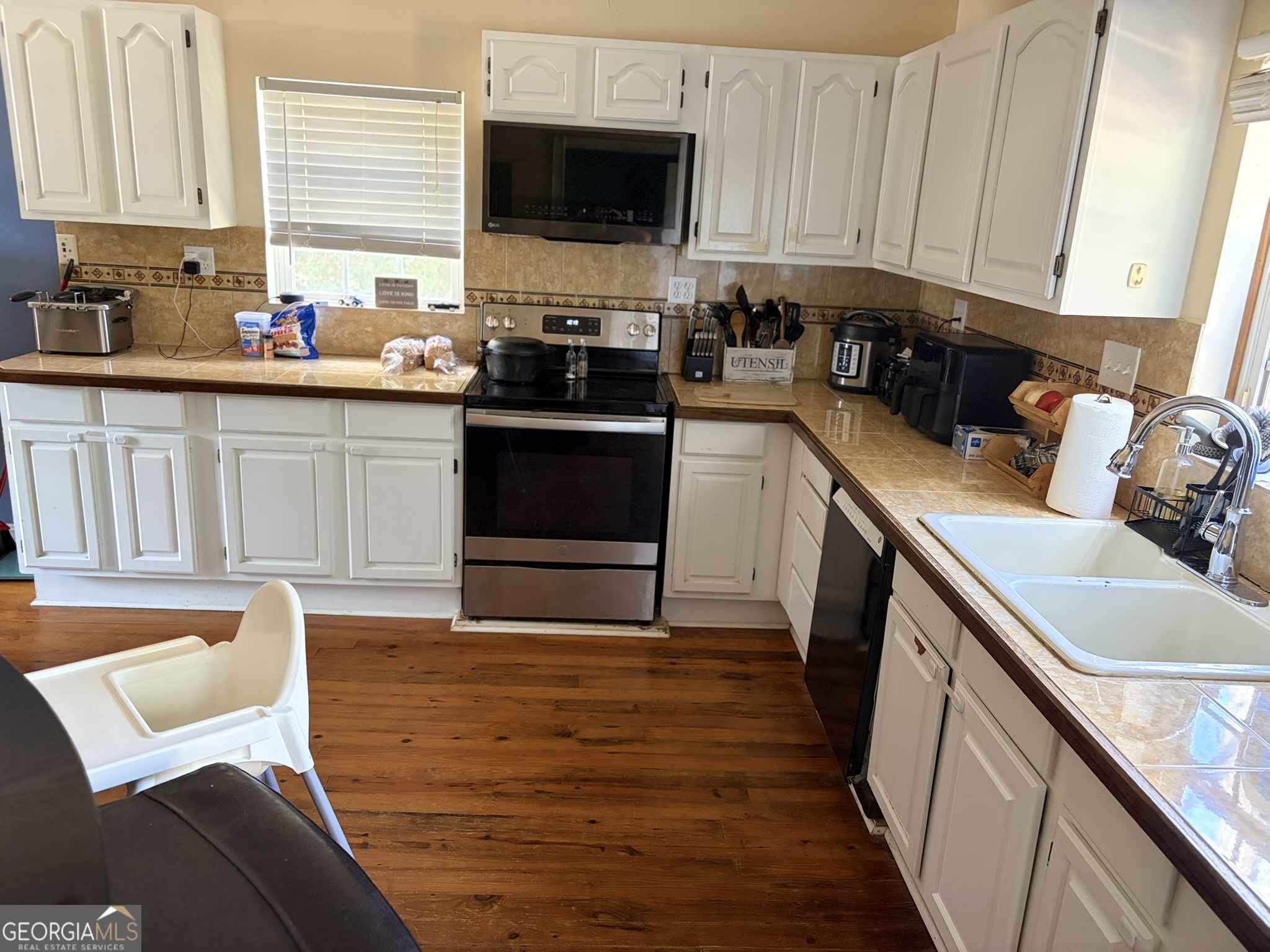 80 Baugh Street Commerce, GA 30529 - Photo 15 of 31 a kitchen with stainless steel appliances a stove top oven a sink a refrigerator a sink and cabinets