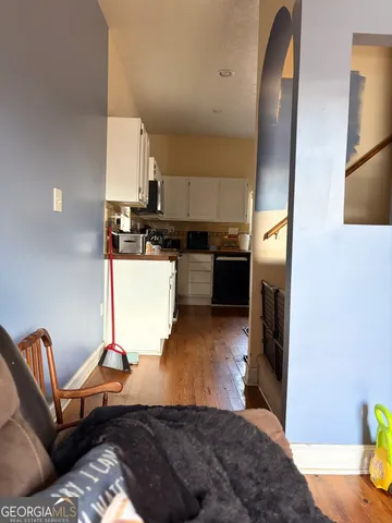 a living room with stainless steel appliances furniture a refrigerator and a counter top