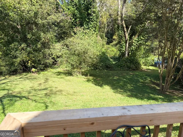 a view of a yard with wooden fence