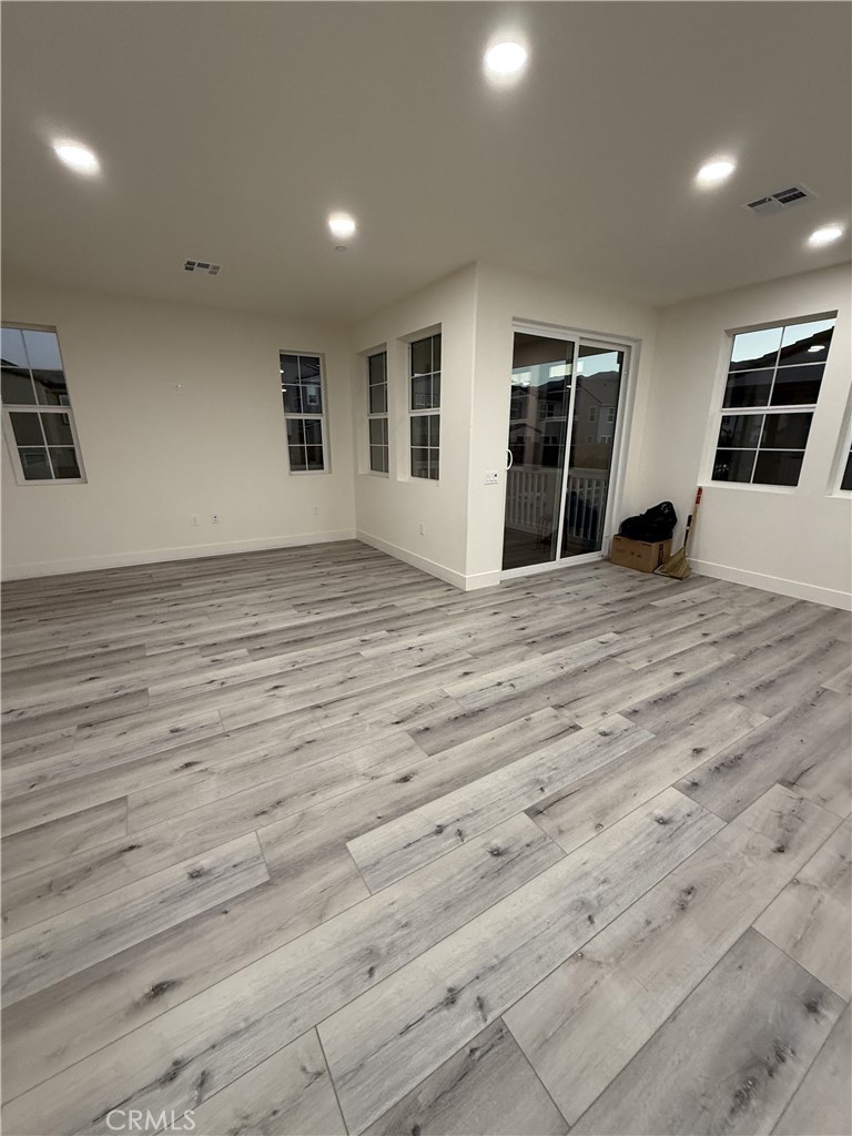 4067 Summer Corona, CA 92883 - Photo 9 of 12 Spacious living area with luxury vinyl plank flooring, recessed lighting, and access to private balcony.