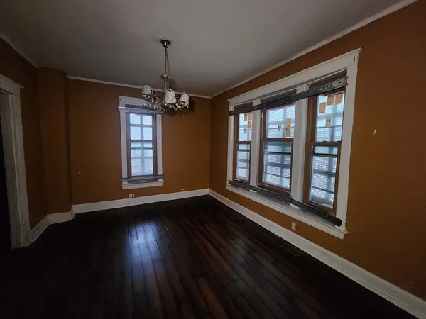 a view of wooden floor chandelier and window in a room