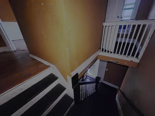 a view of staircase with railing and white walls