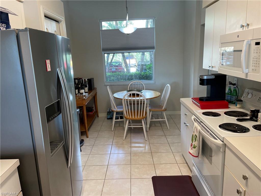Undisclosed Address Naples, FL 34112 - Photo 9 of 28 a kitchen with a refrigerator a stove a sink and a dining table