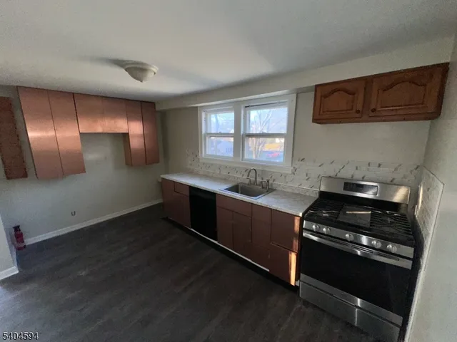 a kitchen with granite countertop stainless steel appliances and wooden cabinets