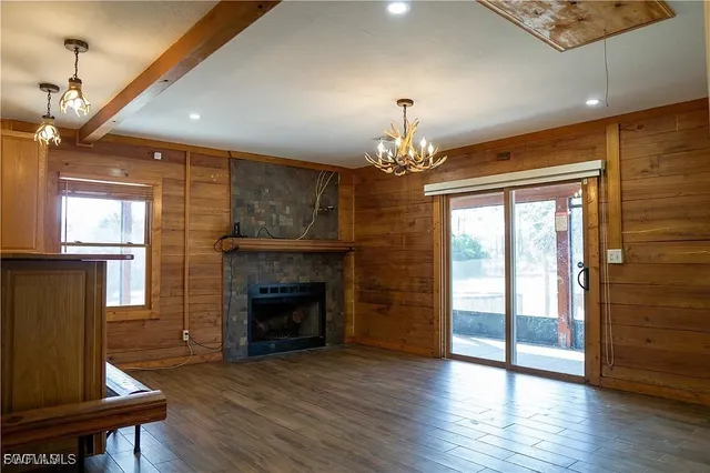 a view of a livingroom with furniture wooden floor fireplace and a window