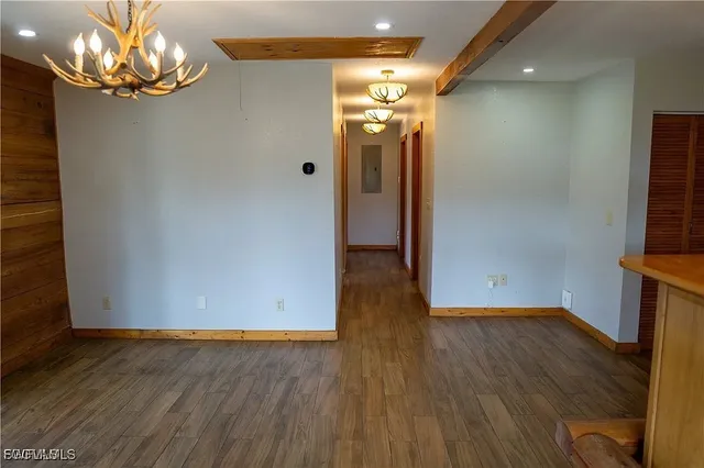 a view of a room with wooden floor and chandelier