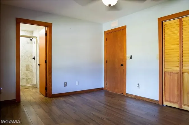 an empty room with wooden floor and closet