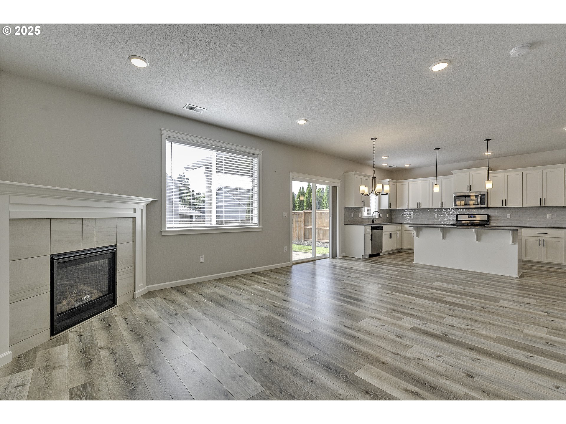 1015 South Nectarine Street Cornelius, OR 97113 - Photo 16 of 36 a view of an empty room with wooden floor and a kitchen