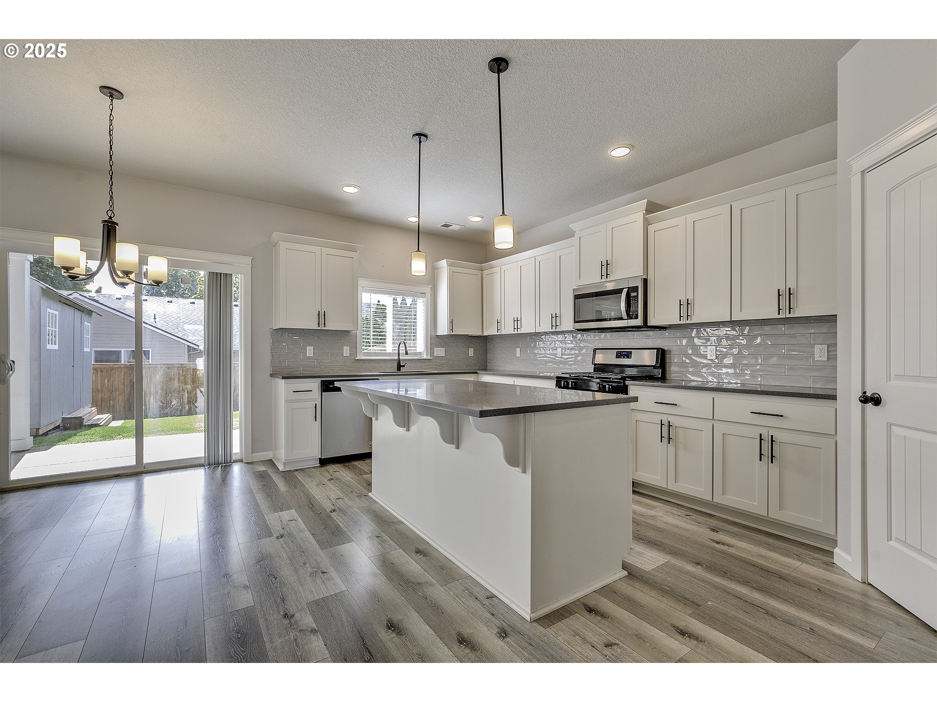 1015 South Nectarine Street Cornelius, OR 97113 - Photo 6 of 36 a kitchen with kitchen island granite countertop a sink cabinets and wooden floor