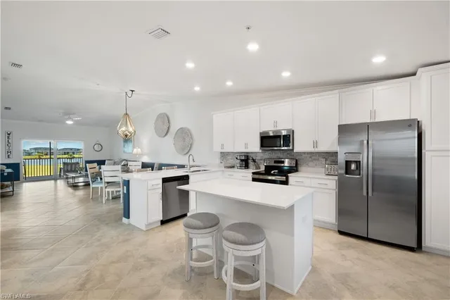 a kitchen with a refrigerator and chairs