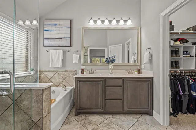 a bathroom with a tub sink and mirror