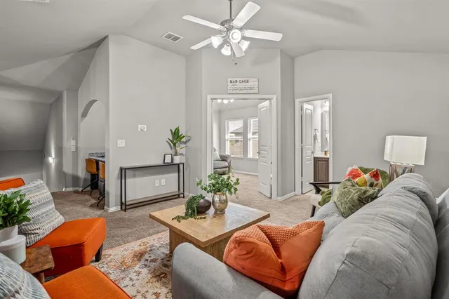 a living room with furniture flowerpot and a chandelier