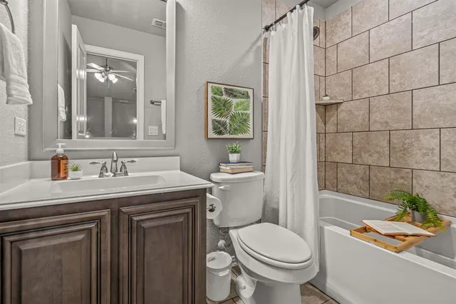 a bathroom with a granite countertop toilet a sink and a mirror