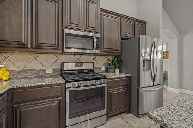 a kitchen with granite countertop a stainless steel appliances and cabinets