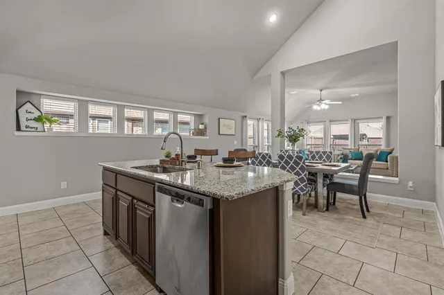 a kitchen with granite countertop a sink and cabinets
