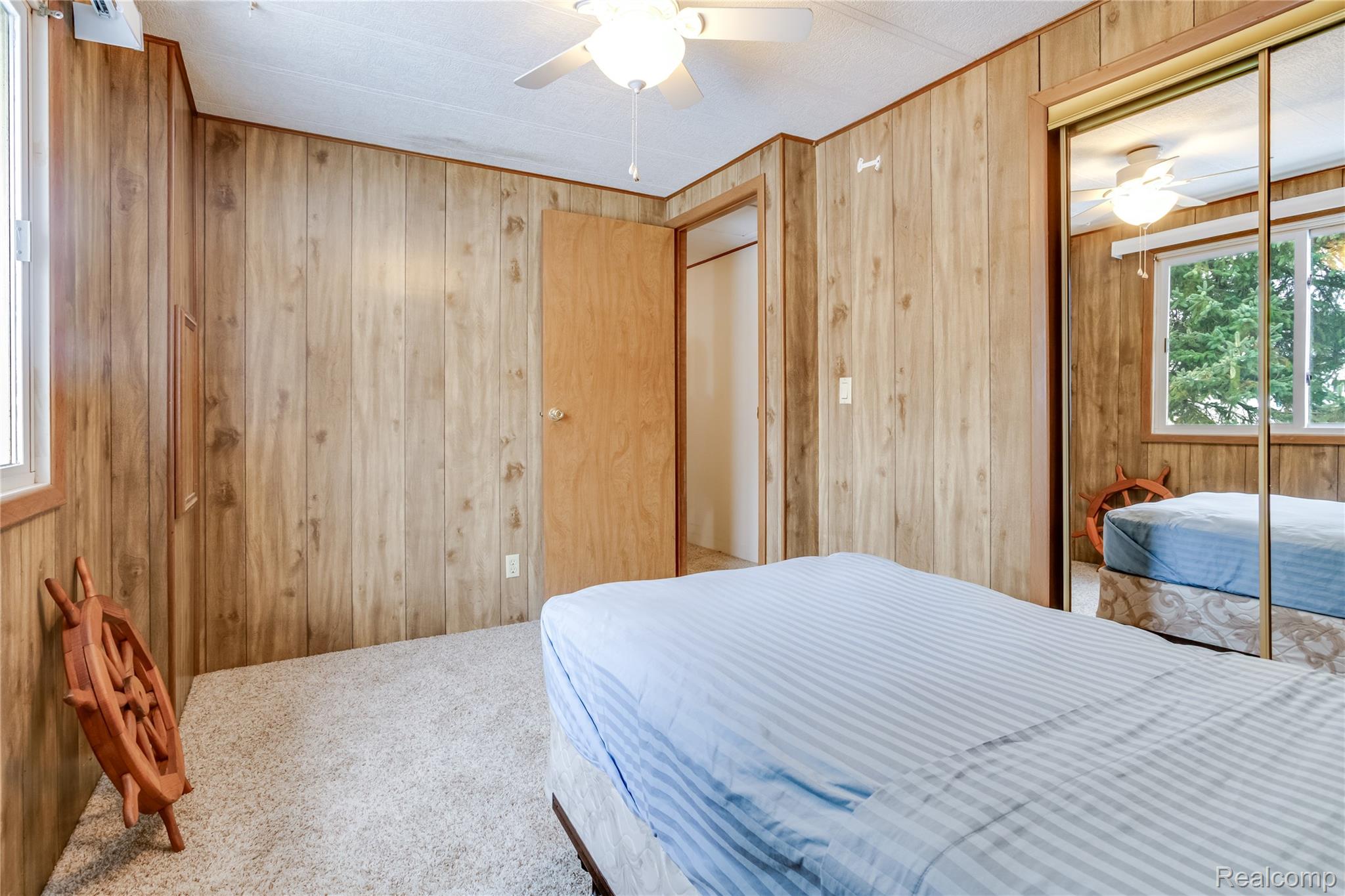 3333 Ravenswood Road Marysville, MI 48040 - Photo 14 of 25 Carpeted bedroom with wood walls, a closet, and ceiling fan