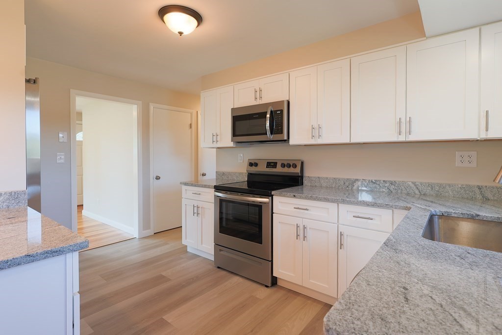 1 Alpine Drive West Boylston, MA 01583 - Photo 10 of 26 a kitchen with granite countertop a stove top oven a sink dishwasher and a refrigerator with wooden floor