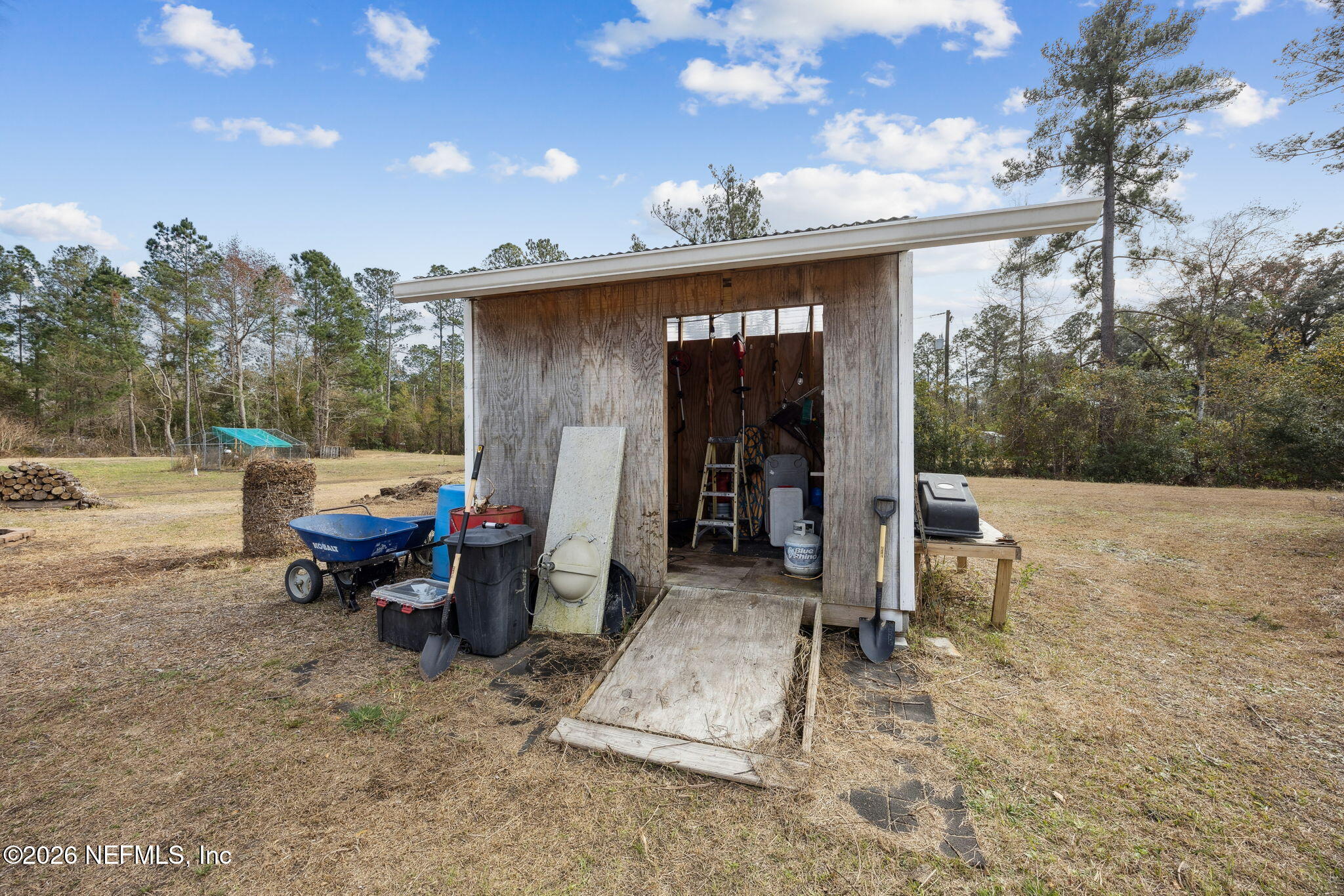 54002 Trooper Court Callahan, FL 32011 - Photo 40 of 56 a backyard of a house with barbeque oven table and chairs