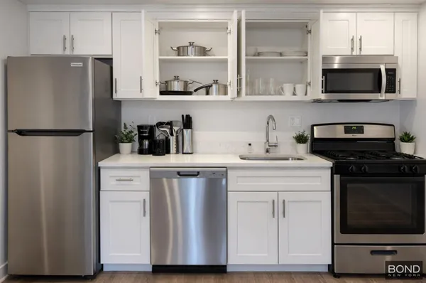 a kitchen with stainless steel appliances a refrigerator stove and microwave