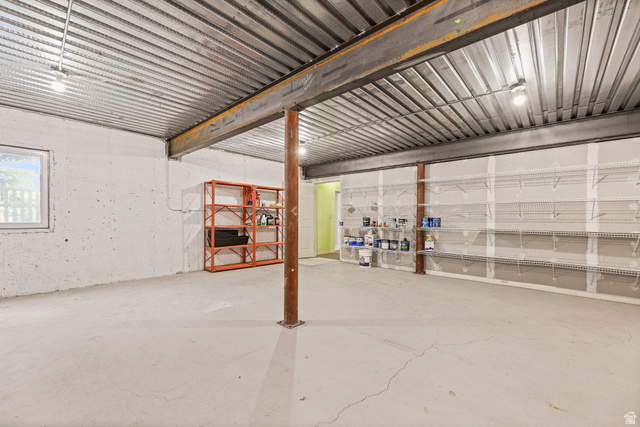 4117 North Wolf Ridge Circle Eden, UT 84310 - Photo 44 of 63 Spacious basement area featuring a concrete floor, exposed metal ceiling, structural support beams, and built-in wall shelving
