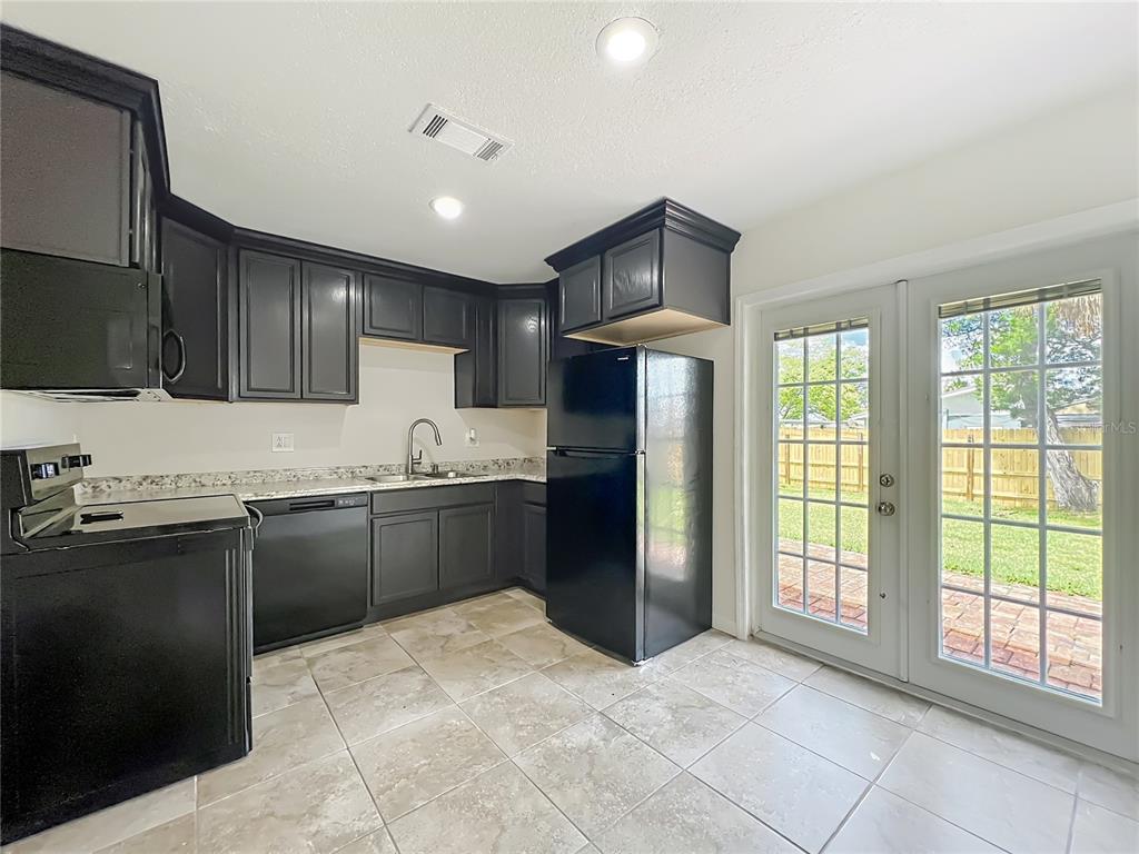 6707 Sierra Terrace New Port Richey, FL 34652 - Photo 13 of 50 a kitchen with granite countertop a refrigerator and a stove top oven