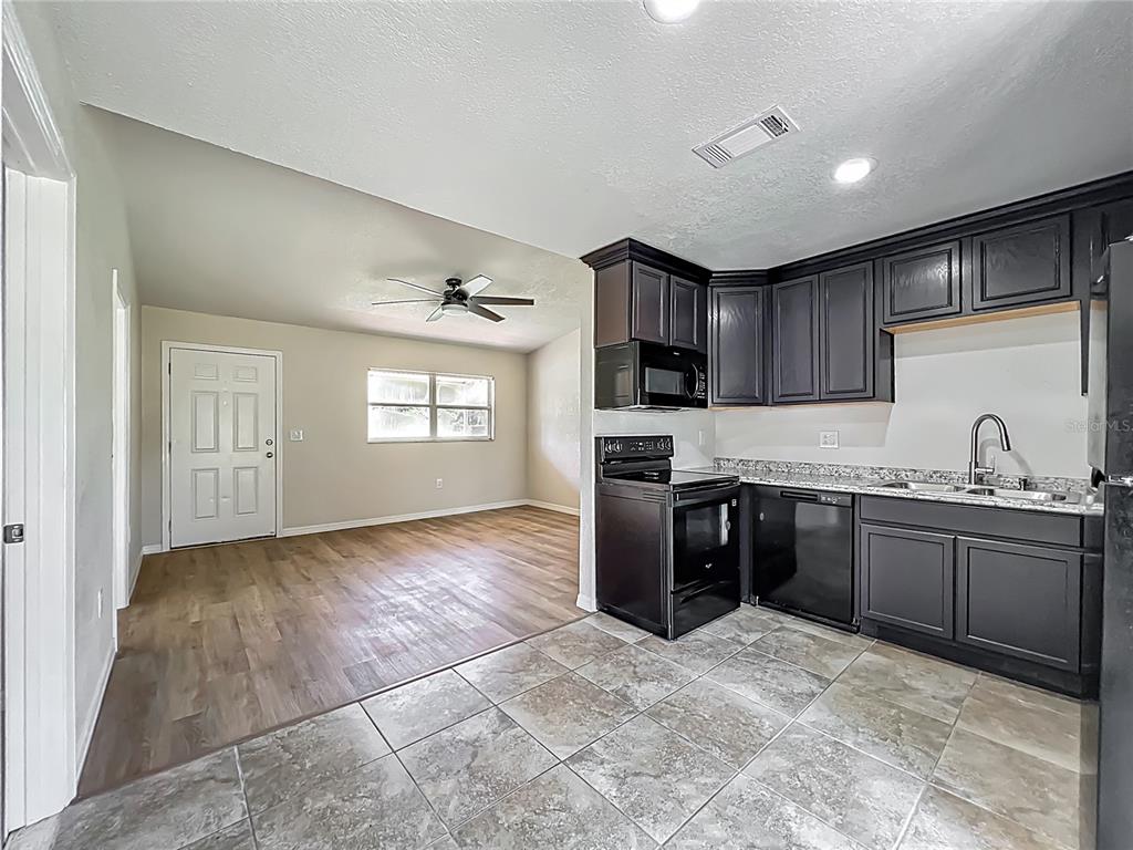 6707 Sierra Terrace New Port Richey, FL 34652 - Photo 14 of 50 a large kitchen with granite countertop a stove a sink dishwasher and a refrigerator