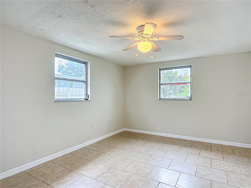 6707 Sierra Terrace New Port Richey, FL 34652 - Photo 29 of 50 an empty room with windows and fan