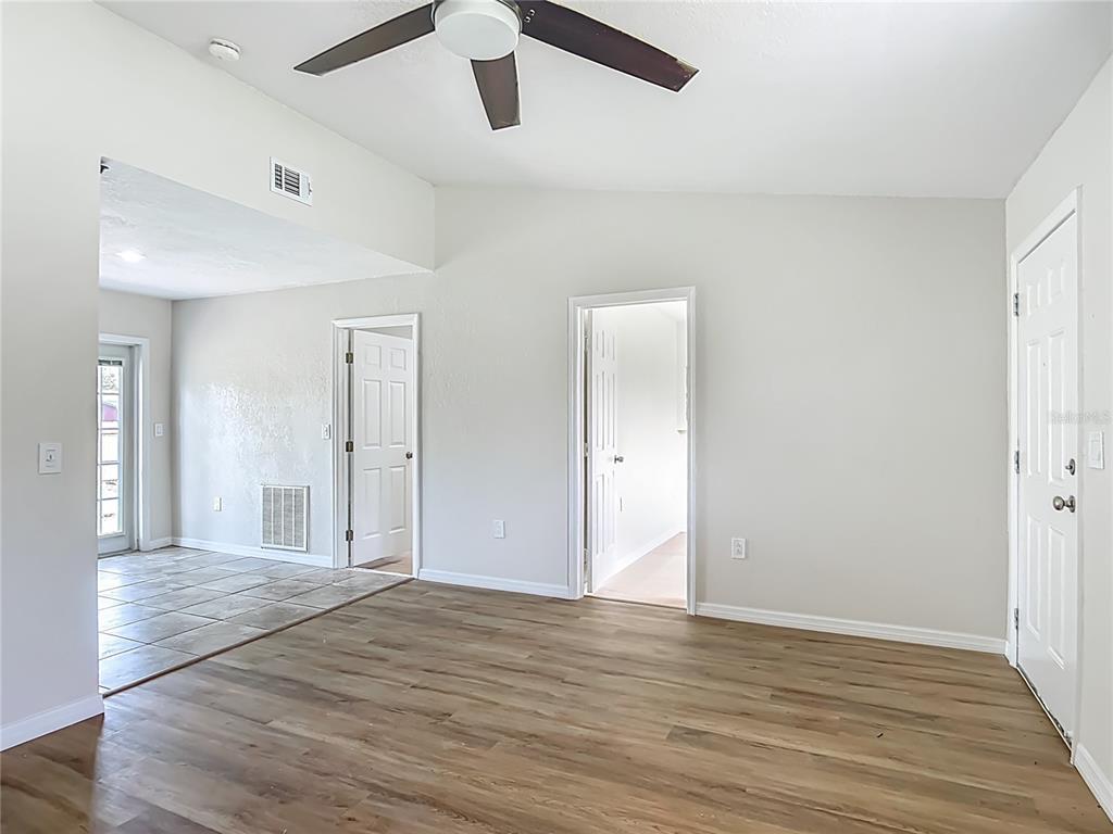 6707 Sierra Terrace New Port Richey, FL 34652 - Photo 9 of 50 an empty room with wooden floor and windows