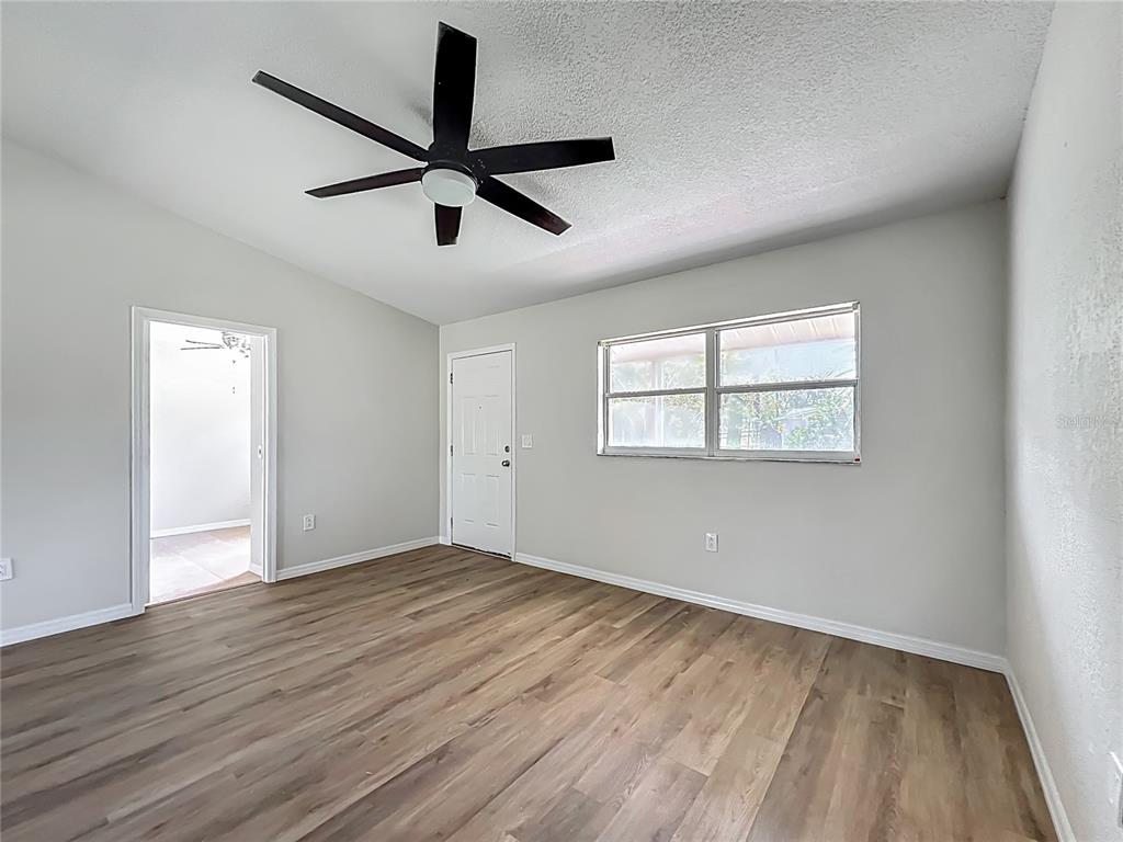 6707 Sierra Terrace New Port Richey, FL 34652 - Photo 10 of 50 an empty room with wooden floor fan and windows