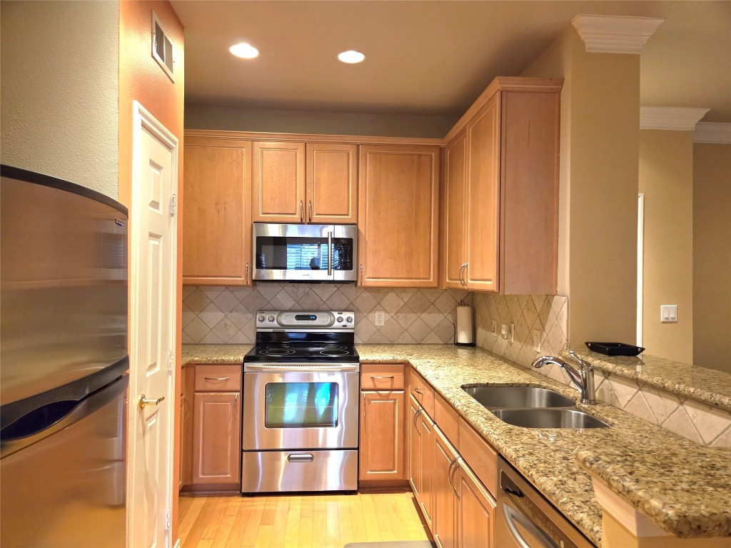 2400 McCue Road, Unit 325 Houston, TX 77056 - Photo 9 of 30 a kitchen with stainless steel appliances granite countertop a sink a stove and a refrigerator