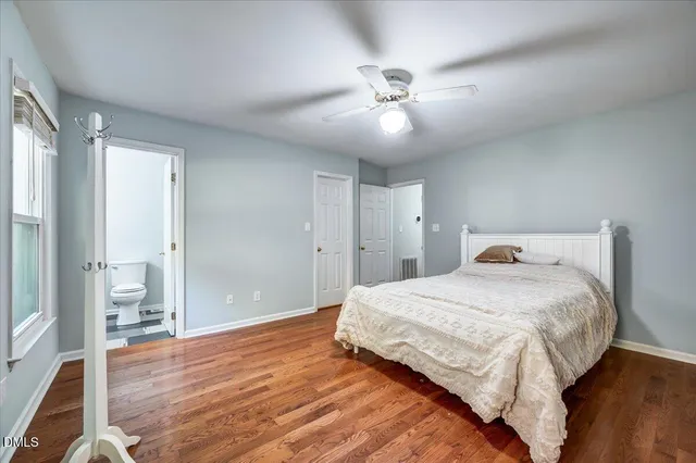 a spacious bedroom with a bed and wooden floor