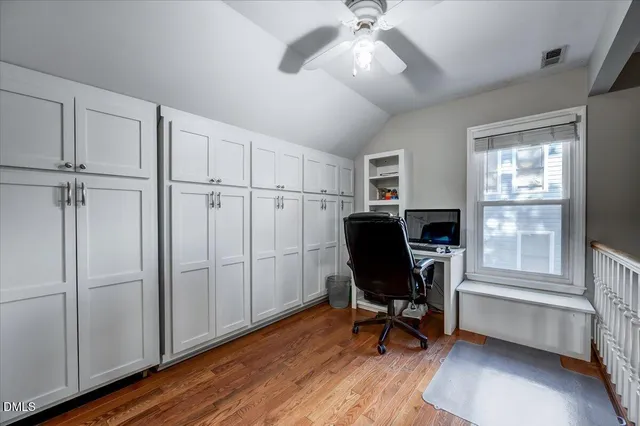 a view of a workspace with furniture and a window