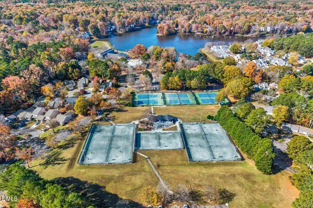 an aerial view of a house with a yard and lake view in back