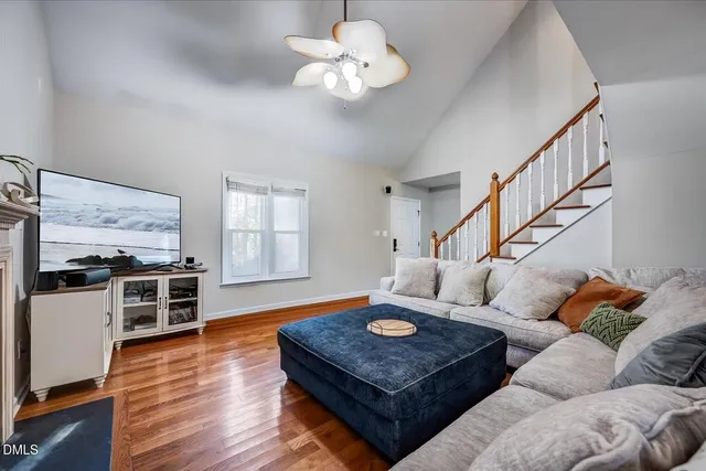 a living room with furniture kitchen view and a large window
