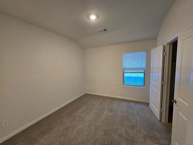 an empty room with windows and closet
