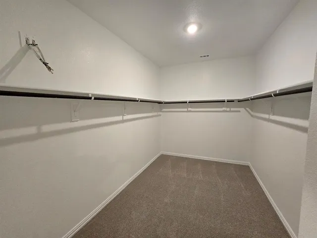 an empty room with a window and a ceiling fan