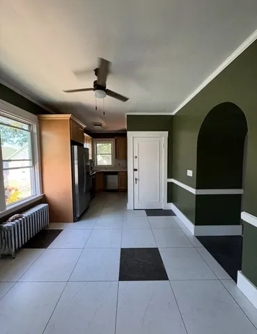 a view of a hallway with furniture and a ceiling fan