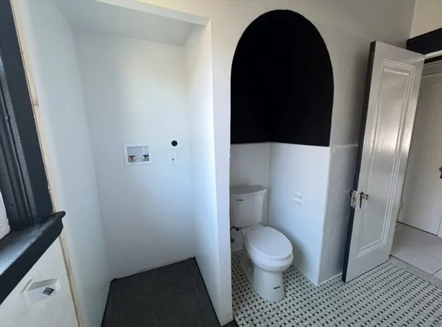 a bathroom with a granite countertop toilet and a sink
