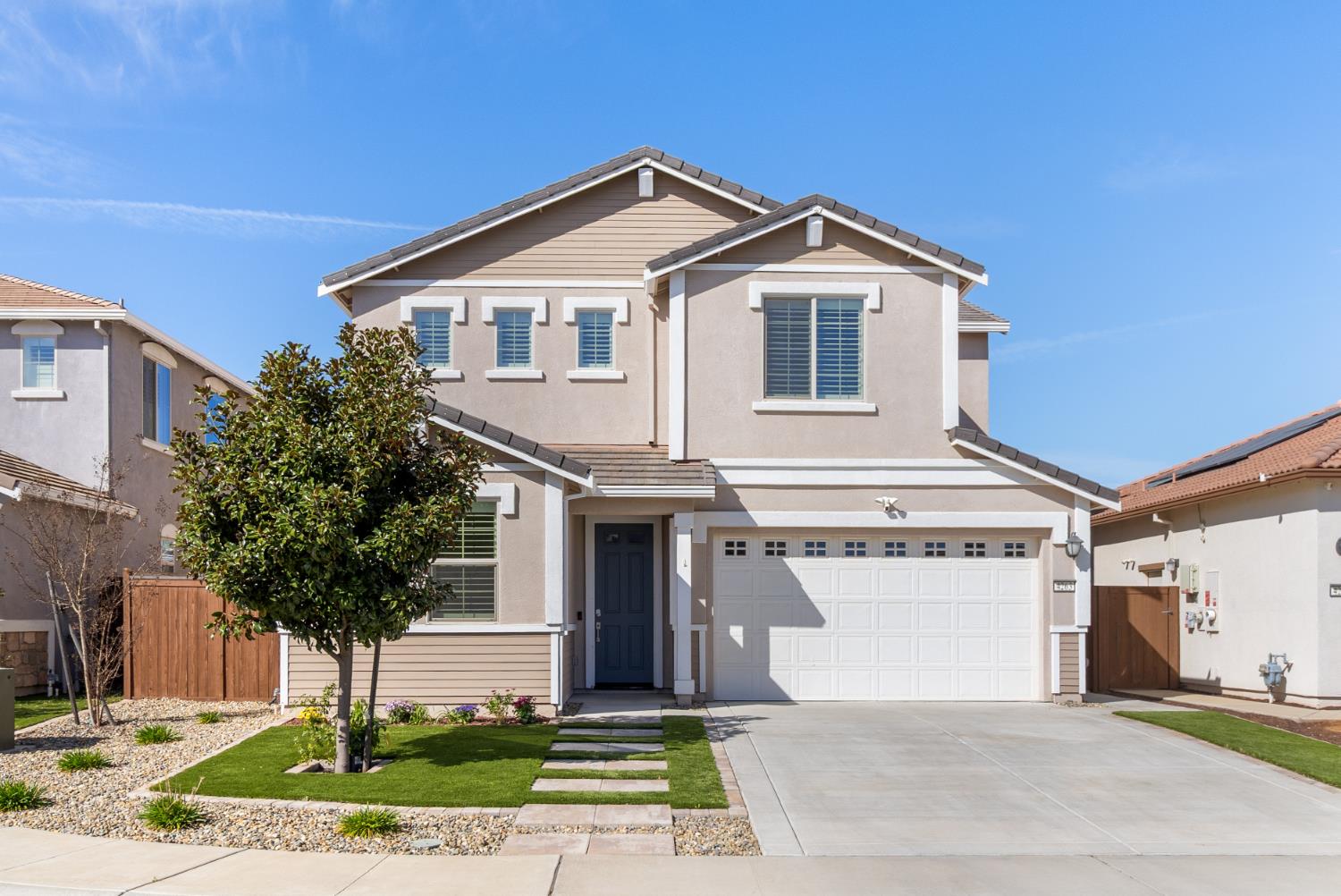 a front view of a house with a yard and garage